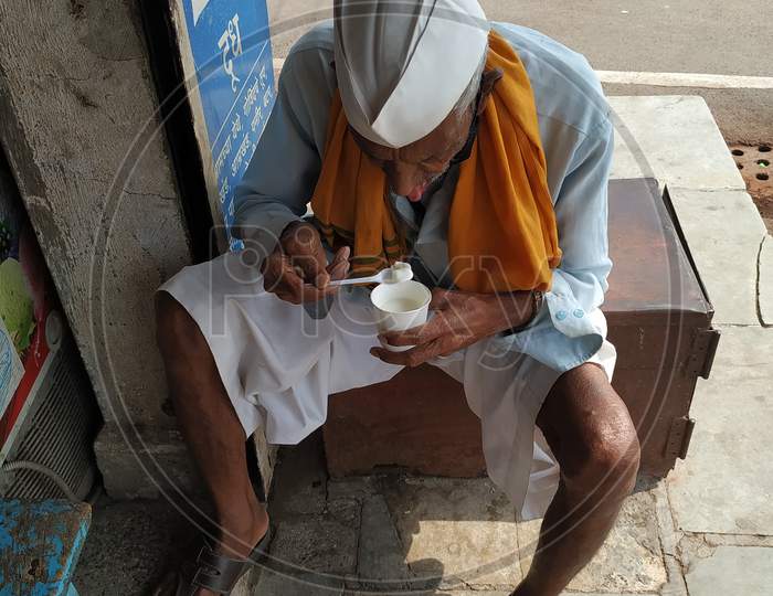 Old man eating icecream on street in sunny days