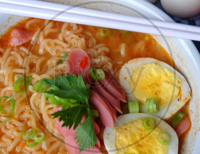 Photo Of Noodle Soup With Toppings Such As Sausages, Eggs, And Vegetables
