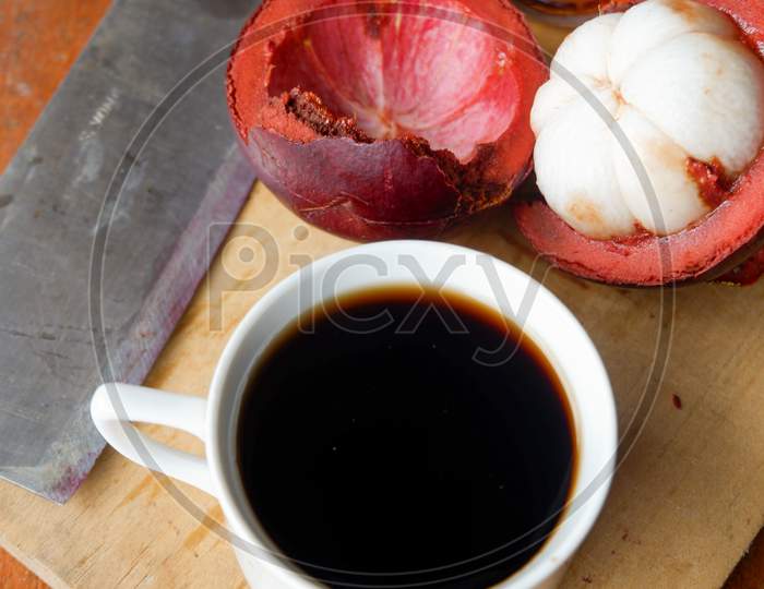 The Photo Is A Photo Of A Person Holding Mangosteen And Tea