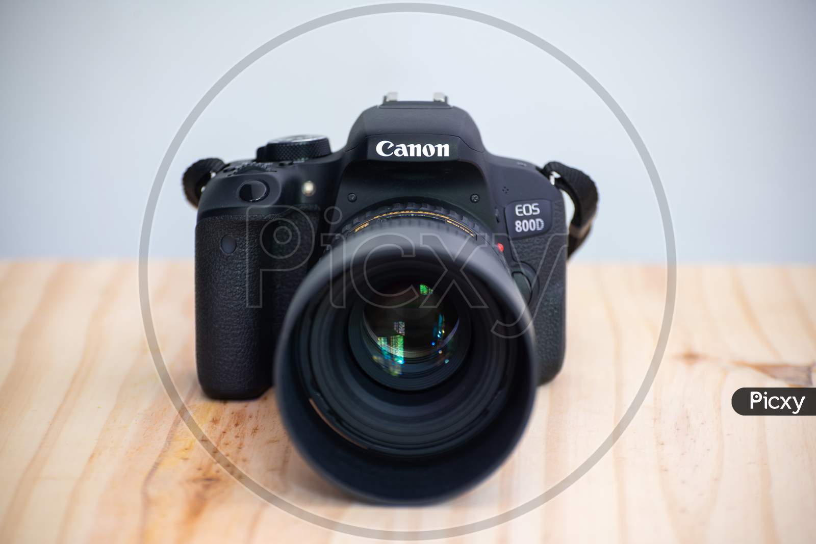 Galle, Sri Lanka - 02 18 2021: Canon Eos 800D Also Known As Rebel T7I Dslr Camera And The Mounted Tokina 100Mm 2.8 Macro Lens With Lens Cap Front View, On A Wooden Table, Neutral Color Background.