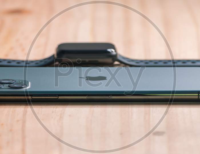 Galle, Sri Lanka - 02 19 2021: Apple Iphone 11 Pro Max And Apple Watch Series 6 Lay Flat On A Wooden Table With Low Angle Side View, Luxury And Lifestyle Concept.