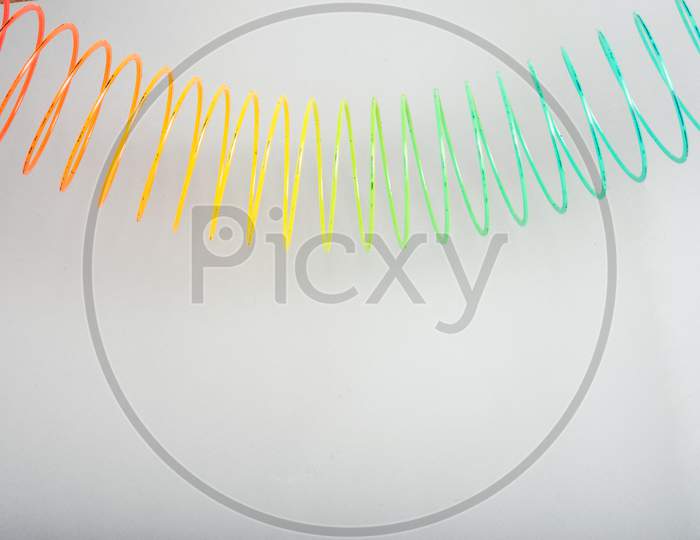 multi-colored spring slinky on a grey background