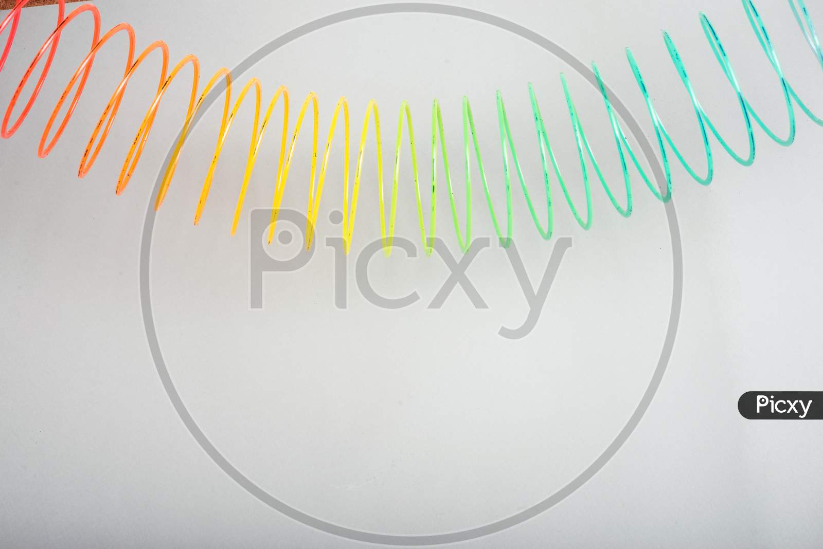 multi-colored spring slinky on a grey background