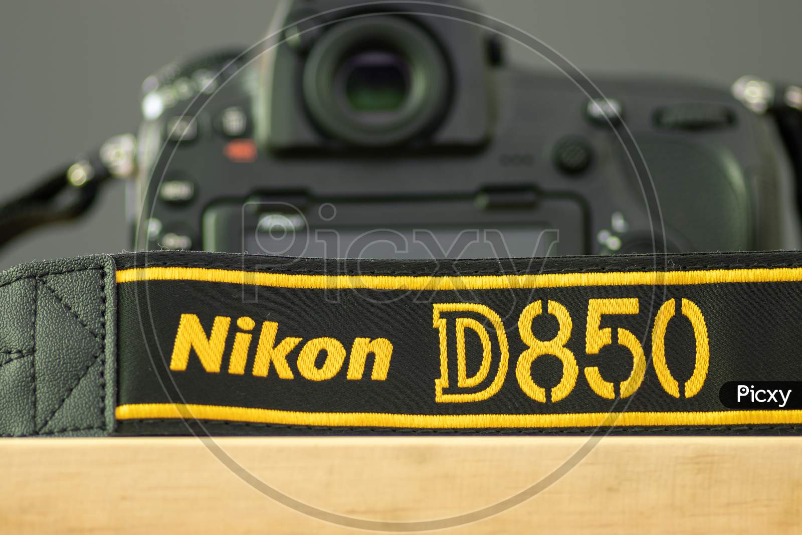 Galle, Sri Lanka - 02 17 2021: Nikon D850 Dslr And Camera Strap On Wooden Table Close Up, Brand New Nikon Logo Embroidered In Yellow Into A Black Ribbon, Professional Factory Finishing Product.