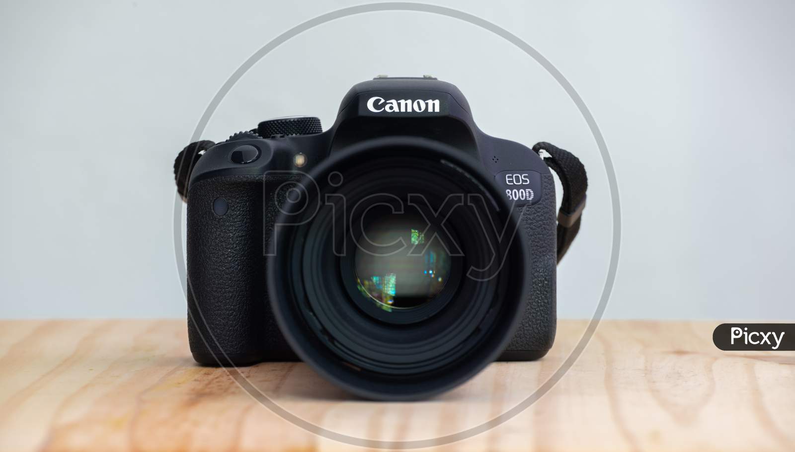 Galle, Sri Lanka - 02 18 2021: Canon Eos 800D Also Known As Rebel T7I Dslr Camera And The Mounted 100Mm Macro Lens Front View, On A Wooden Table, Neutral Color Background.