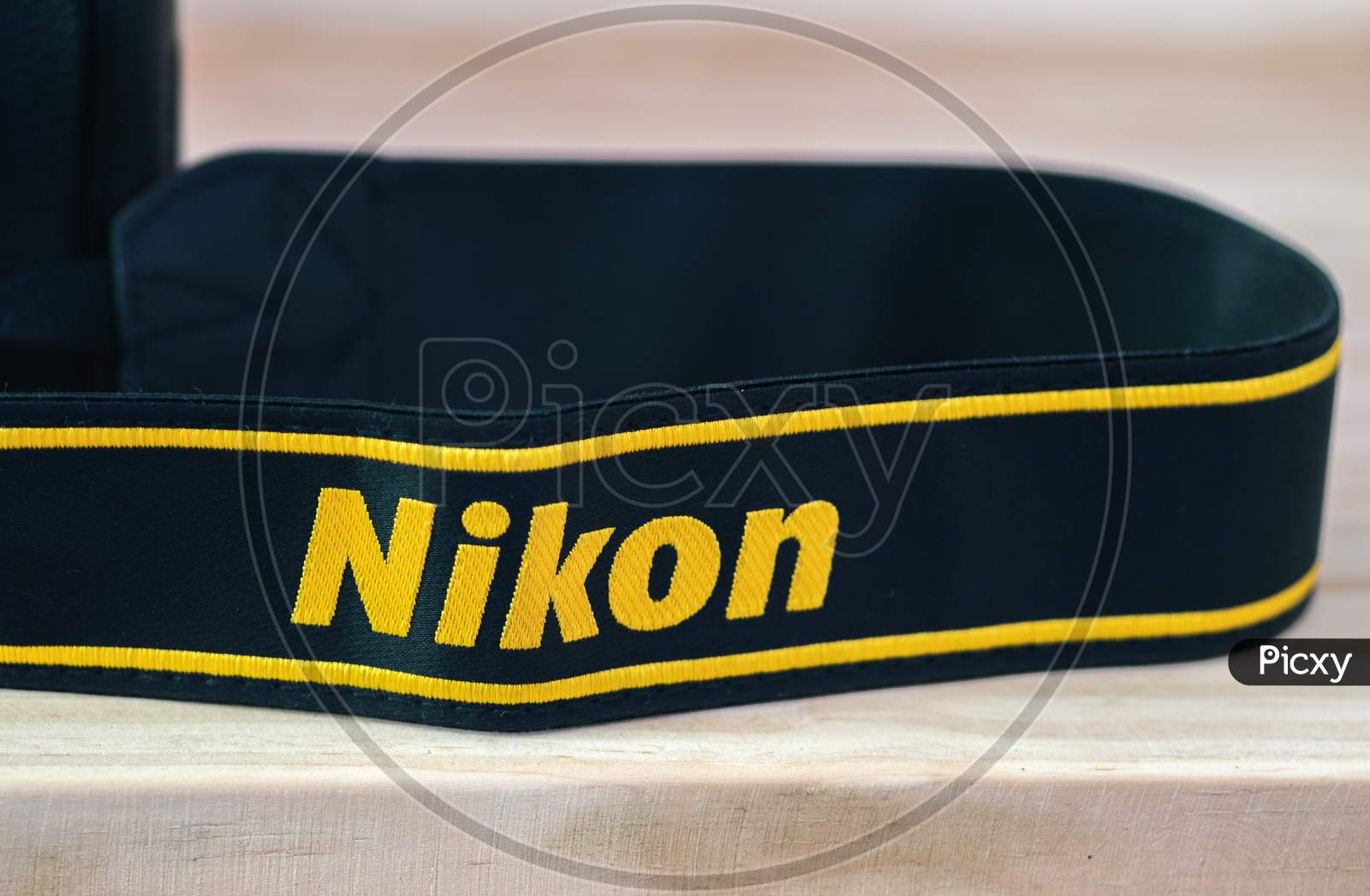 Galle, Sri Lanka - 02 17 2021: Nikon Dslr Camera Strap On Wooden Table Close Up, Brand New Nikon Logo Embroidered In Yellow Into A Black Ribbon, Professional-Grade Factory Finishing Product.