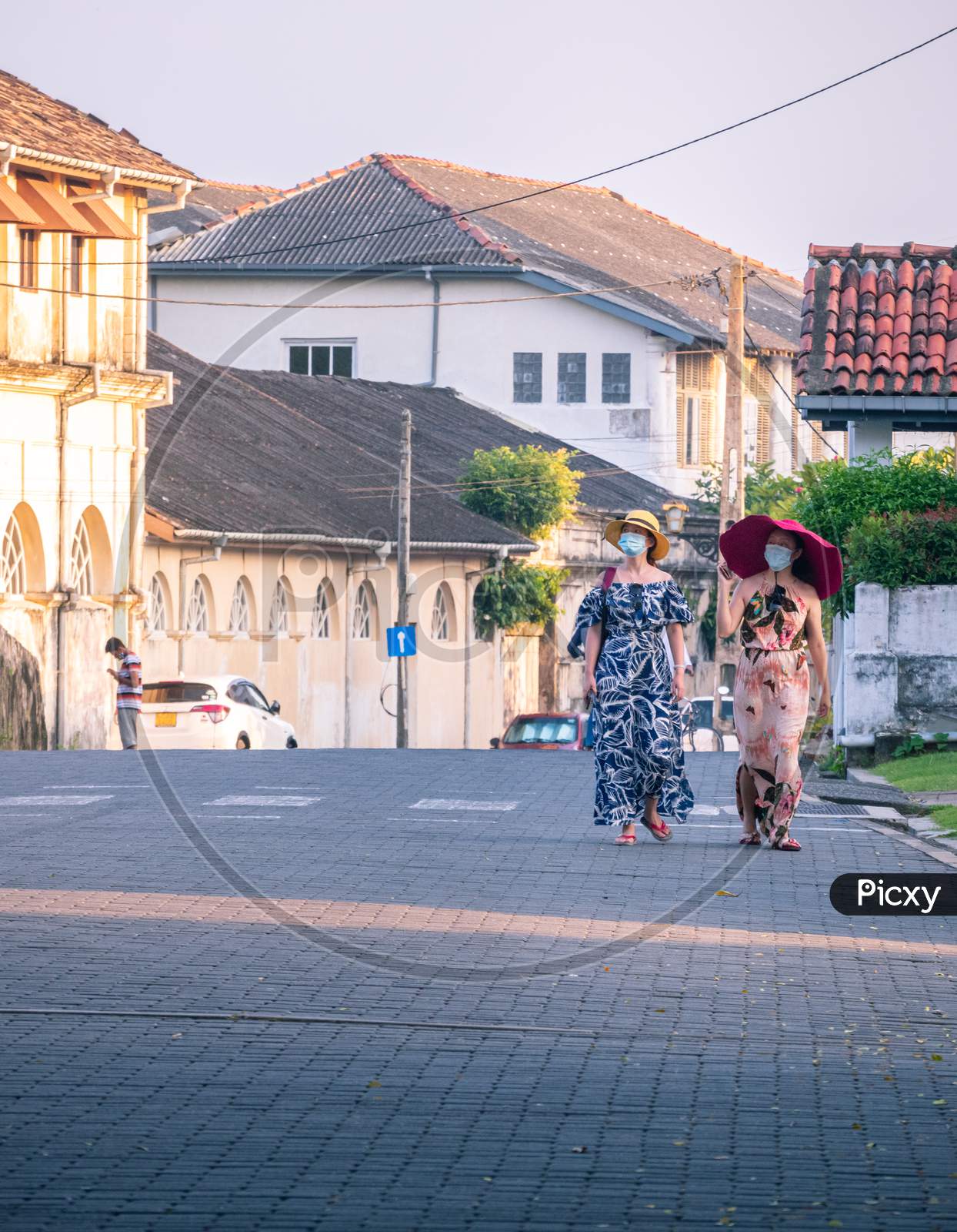 Galle, Sri Lanka - 02 12 2021: Two Female Tourists With Big Hats Walks In The Streets Of Galle Fort In The Evening, Enjoying The Beautiful View Of Colonial Age Built City. Interlock Blocks Street.
