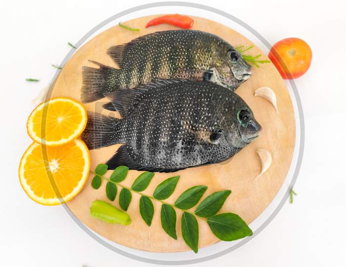 Pearl Spot Fish /Karimeen Decorated With Herbs And Fruits. Isolated On White Background.Selective Focus.