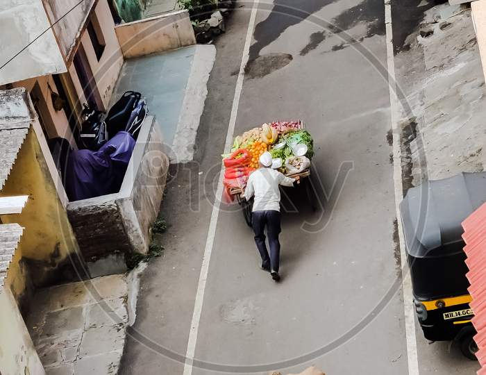 Two in a row Vegitable carts dragging by old men in a street for selling