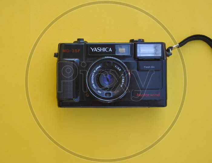 Mandi, Himachal Pradesh, India - 04 24 2021: High angle view of a Yashica film roll camera MD-35f isolated over yellow background