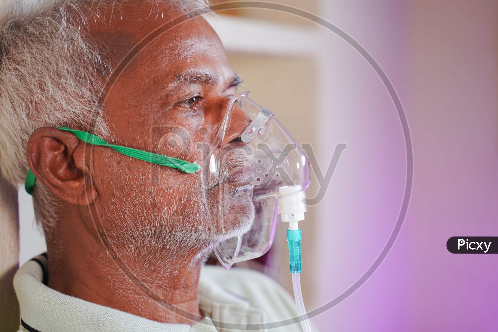 Close Up Head Shot Of Old Man Breathing On Ventilator Oxygen Mask At Home Due To Coronavirus Covid-19 Breathing Problem And Viral Infection