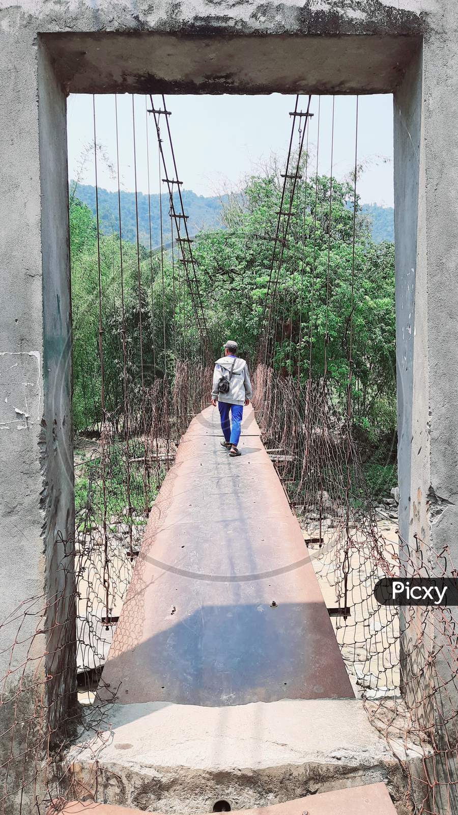 A person is stepping on Palang River Bridge at Pacha, Seppa