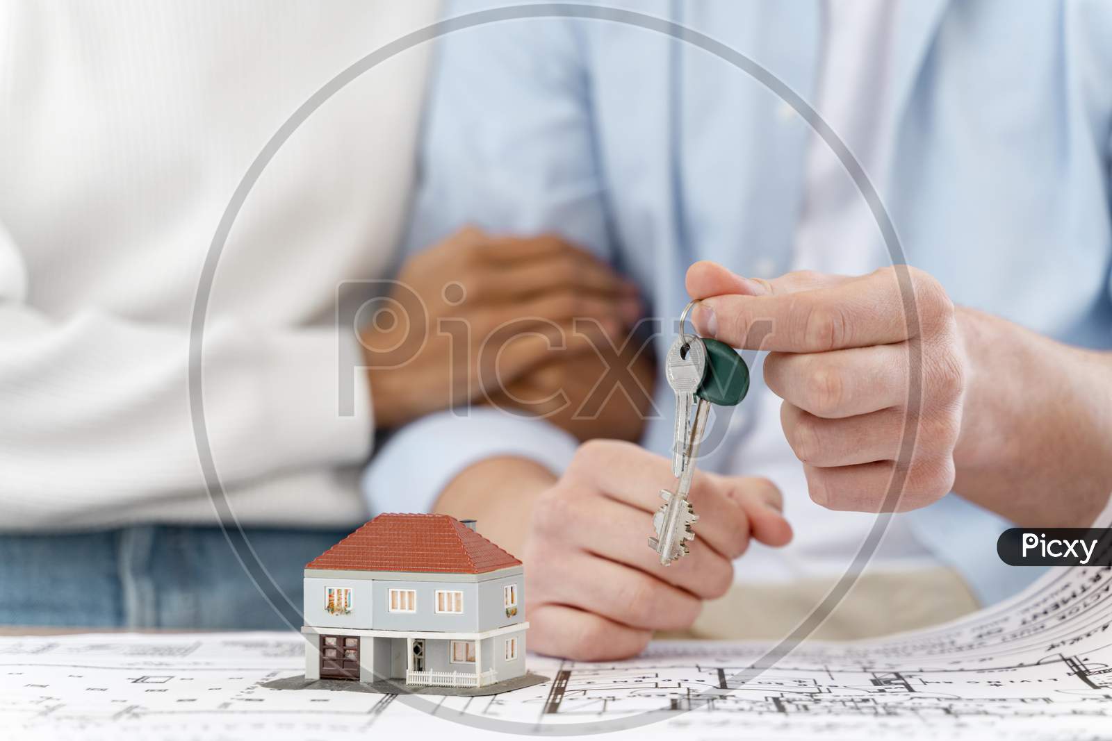 embraced defocused couple holding keys their new house