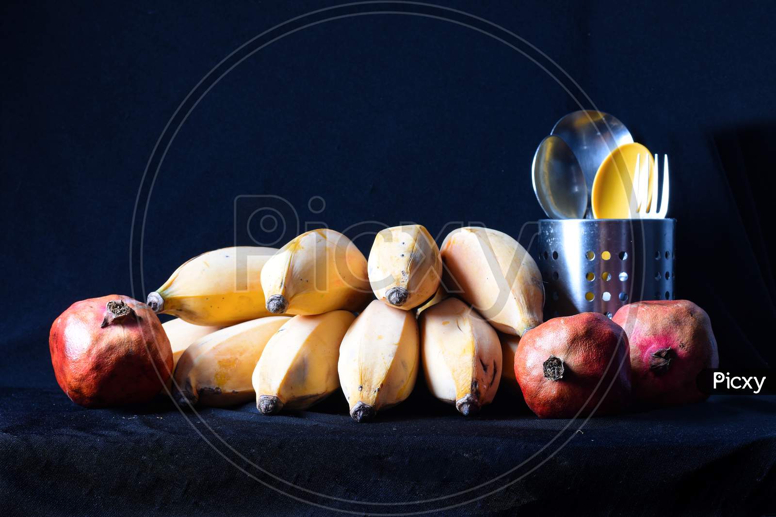 Yellow Ripe Bananas And Red Pomegranates With Cutlery
