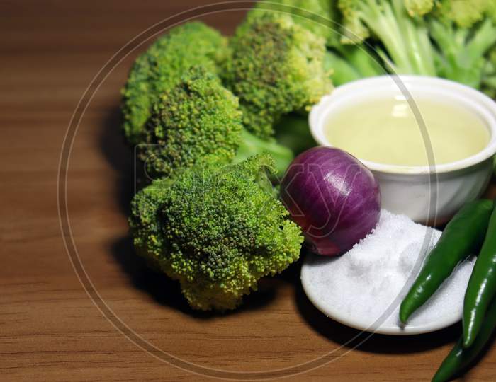 Sliced Broccoli With Spices Stock On Wooden Table