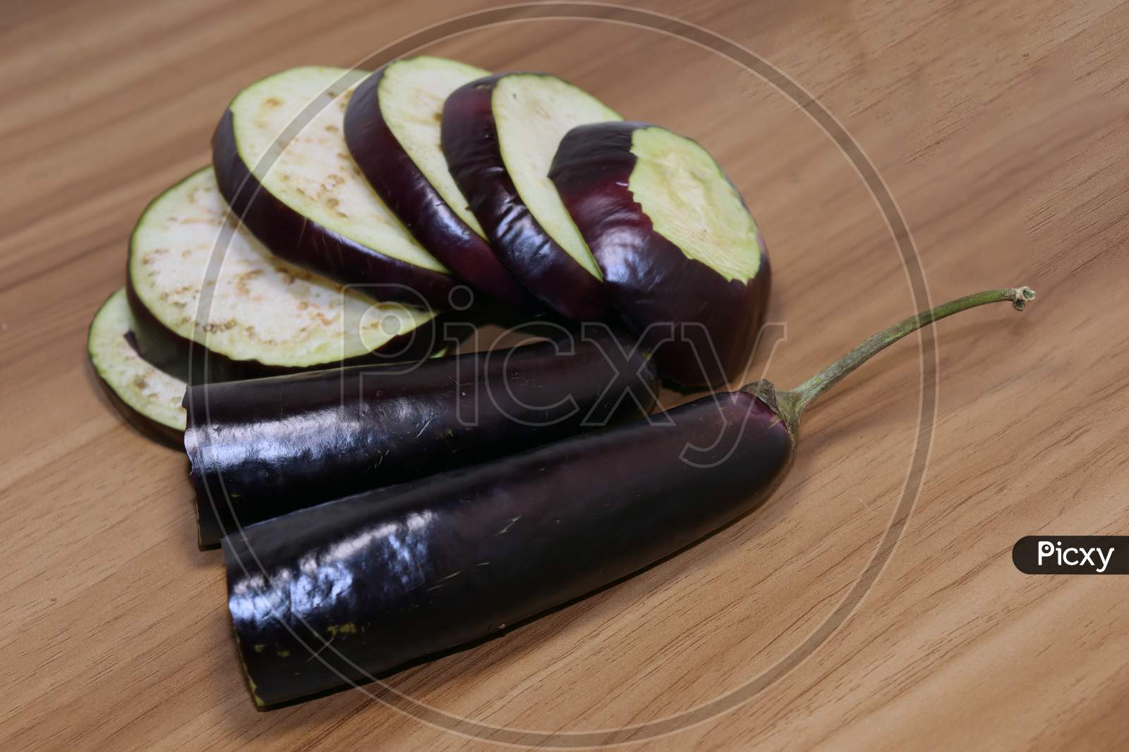 Violet Colored Brinjal On Wooden Table For Cooking