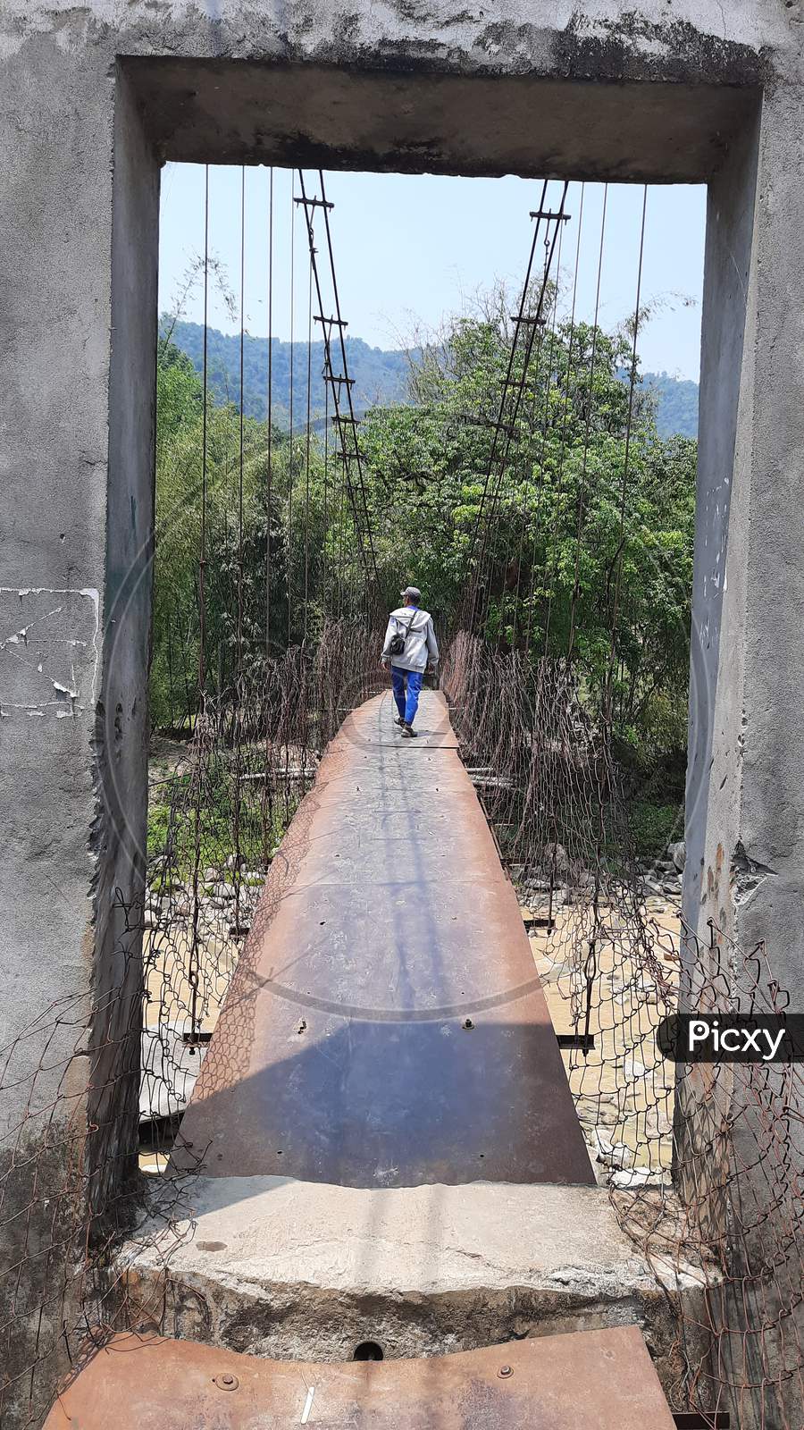 A person is stepping on Palang River Bridge at Pacha, Seppa