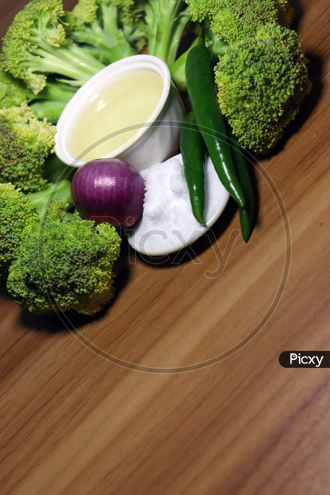 Sliced Broccoli With Spices Stock On Wooden Table