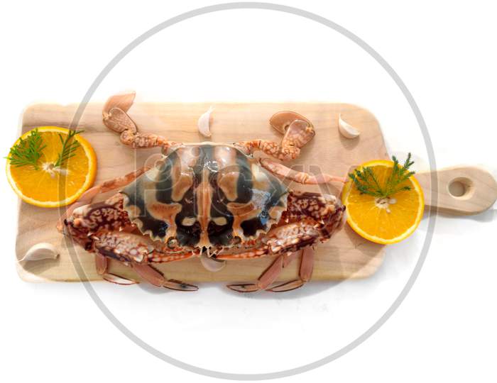 Fresh Crucifix Crab Decorated With Herbs And Fruits On A Wooden Pad.Isolated On White Background.Selective Focus.