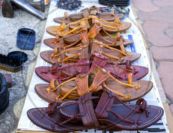 Stock Photo Of Popular And Traditional Kolhapuri Chappal Kept On Roadside For Sale At Indian Market.It Is Handmade Leather Chappal With Unique Design And Color.