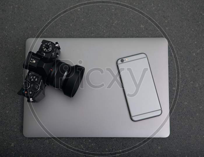 sliver laptop, smartphone and black camera