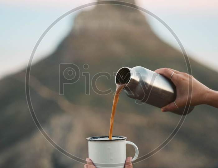 pouring coffee from a flask into a cup