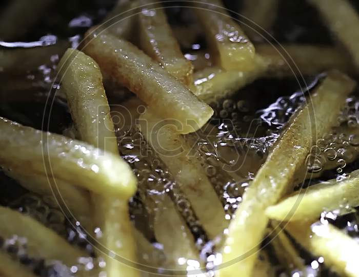 Cooking french fries. Close up of Frying French fries in the fryer in hot oil