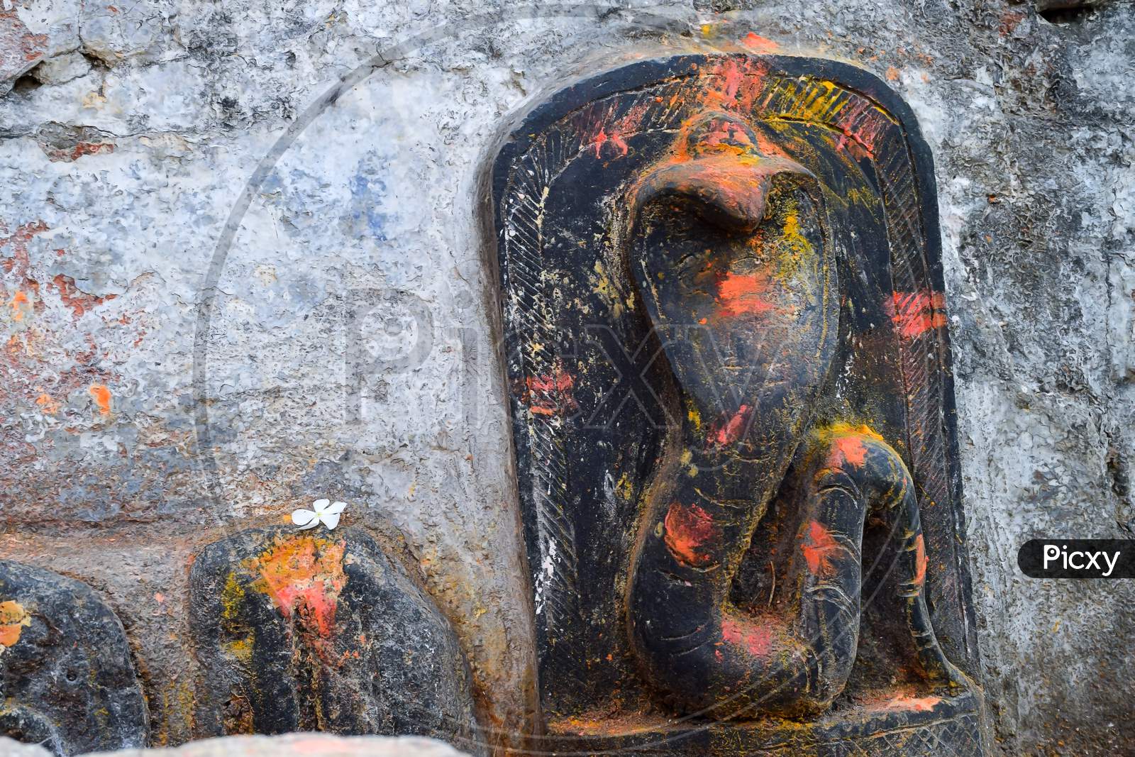 Stock Photo Of Old Snake Temple In Mailar Karnataka India. Stone Idol Carved In Blacks Tone, Turmeric Powder And Vermillion And Flower Offering On Snake Idol For Worshiping . Blur Background.