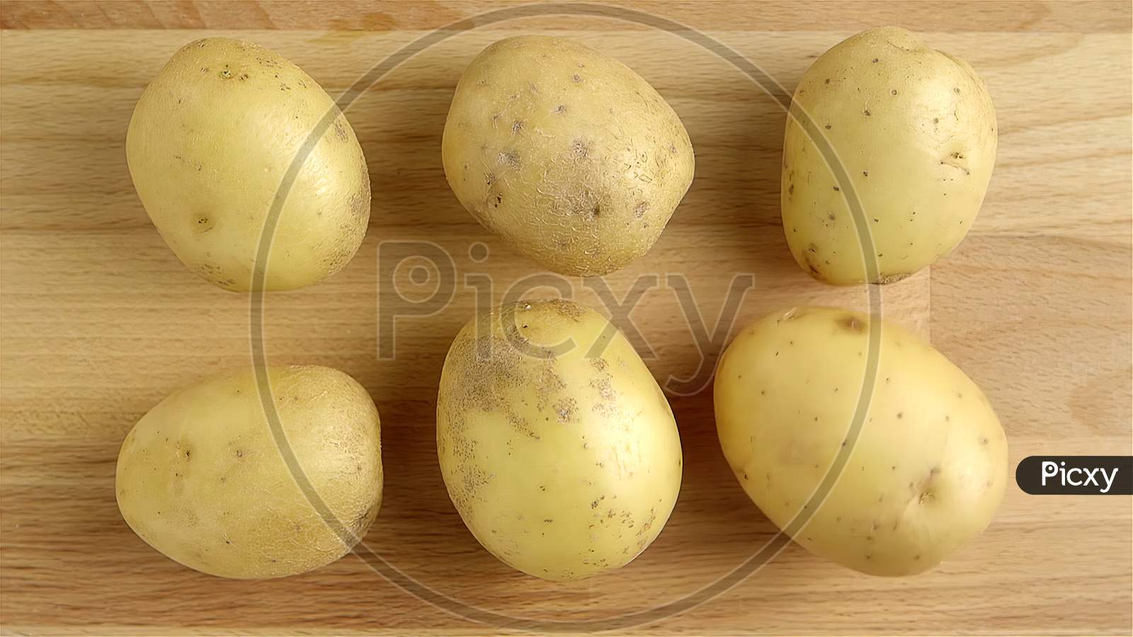 A pile of uncooked white potatoes on a distressed wooden background. Top view