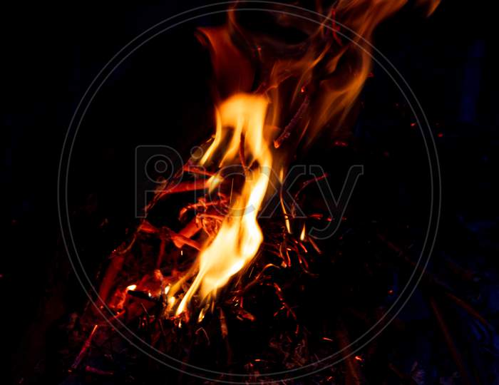 Shiny burning fire in the dark shows the romantic side of a campfire or bonfire, fire safety and the need of a fire insurance as well as survival adventures outdoor with the children and the family