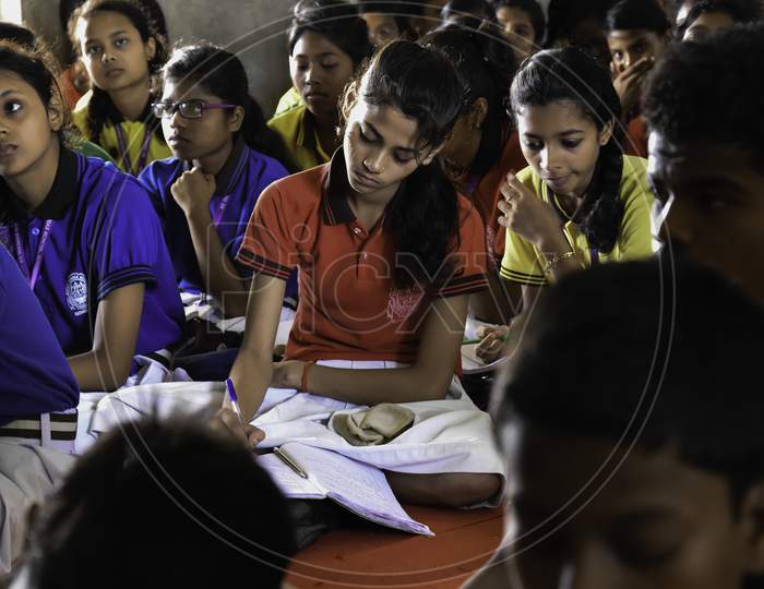 Group of Indian Government school girls students in uniform studying hard from books in the classroom of their school. Inside class room. Kanya Vidyalaya.