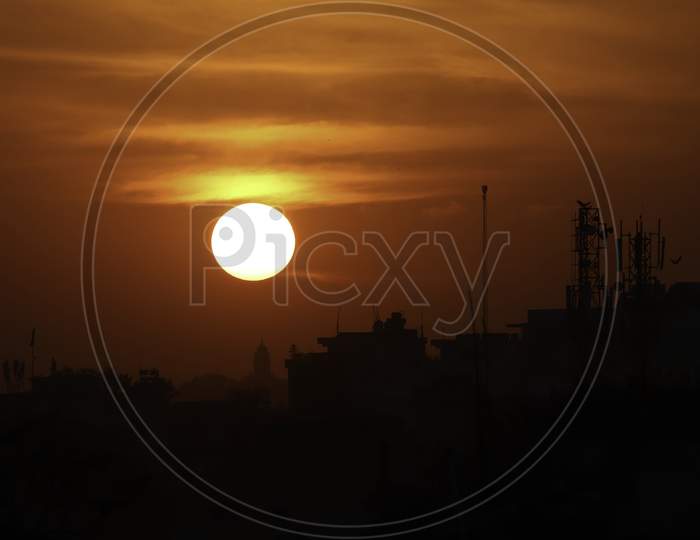 Dark silhouette of sunset over a city in India.