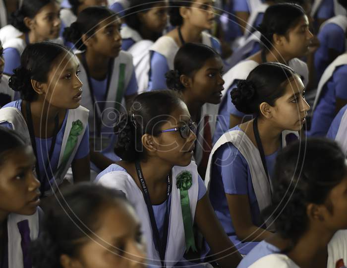 Group of unidentified Indian girl students of government school inside the class room sitting on floor smiling and enjoying class activity.