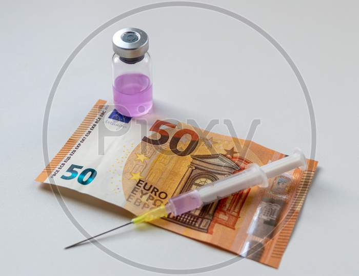 Health care costs for medicine and therapy drugs with injection needles and medicine ampullas stand beside european bank notes and euro coins to show medical expenses and medical research