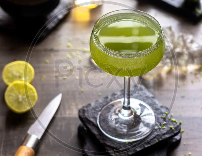 Fresh summer drink Cold lemonade in the wooden table with lemon slice and knife.