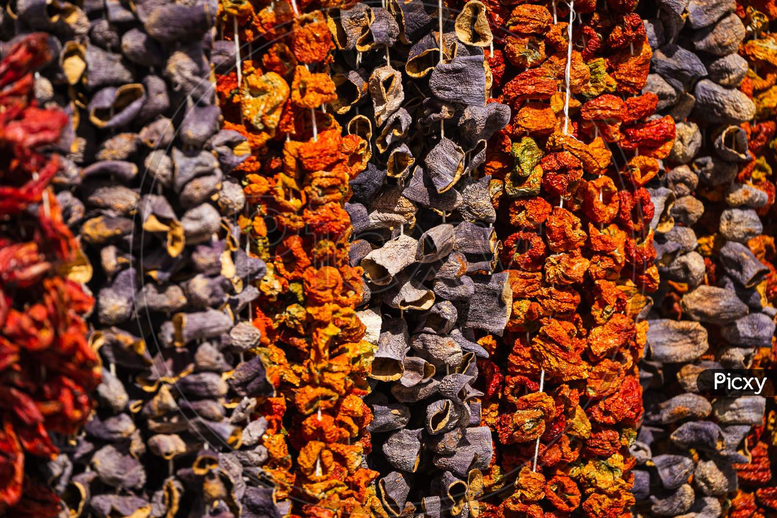 Close-Up Of Beautiful Rows Of Dried Chilli And Hot Peppers. Various Nuts On The Market Showcase