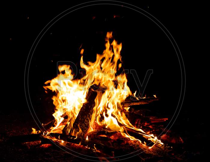 Shiny burning fire in the dark shows the romantic side of a campfire or bonfire, fire safety and the need of a fire insurance as well as survival adventures outdoor with the children and the family
