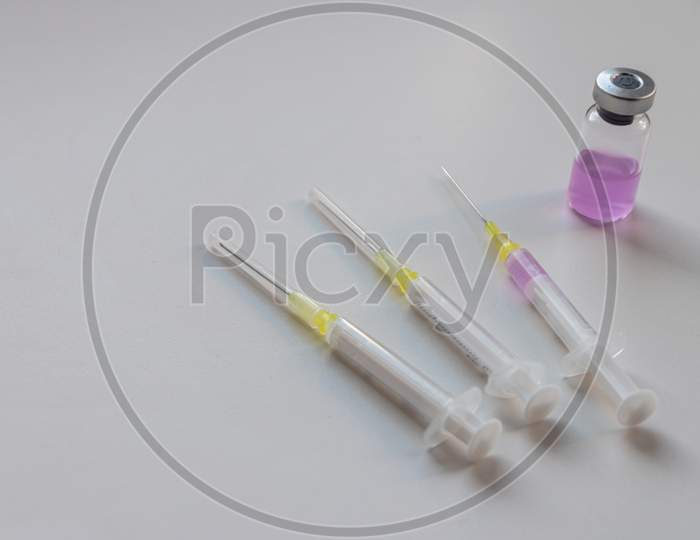 Pink drug in an ampulla ready for injection with a syringe to cure or make high or heal corona virus infections as immunization and protection vaccine against covid and corona virus