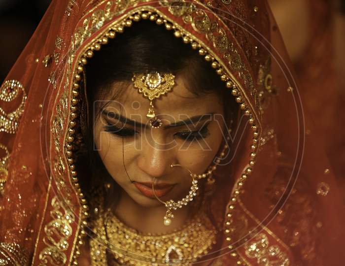Stunning Indian bride dressed in Hindu red traditional wedding clothes.  Image of a gorgeous Indian bride traditionally dressed.
