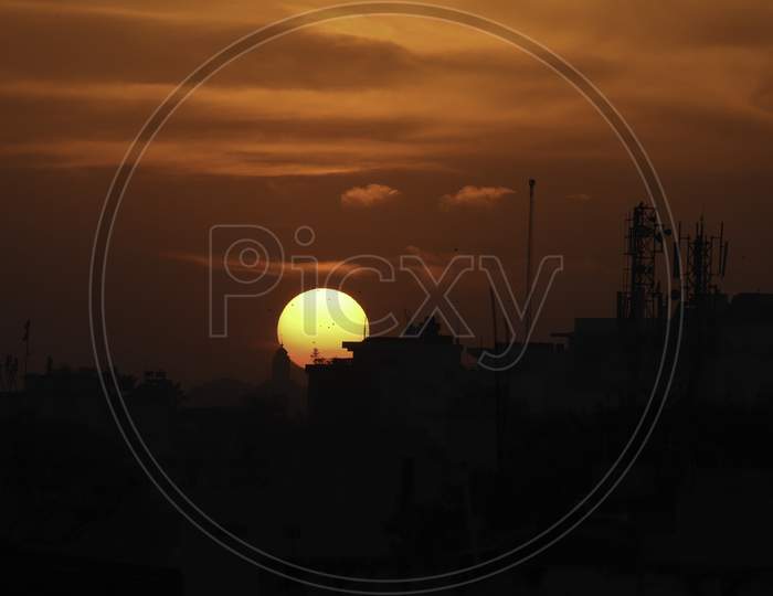 Dark silhouette of sunset over a city in India.