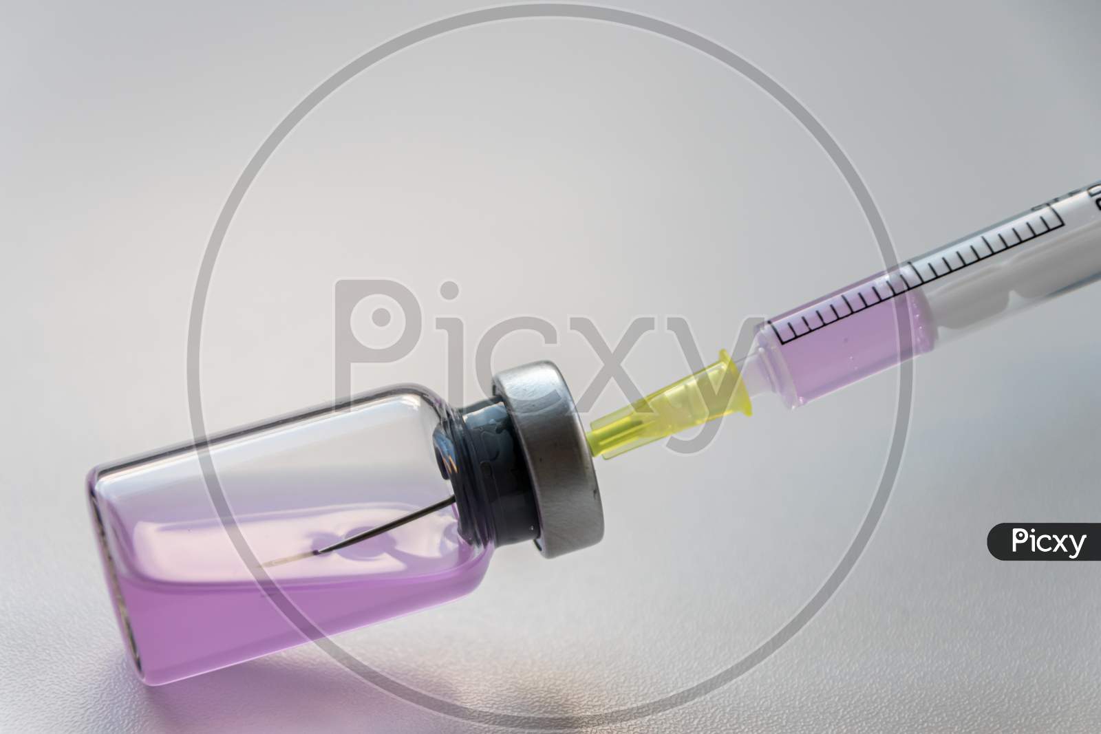 Pink drug in an ampulla ready for injection with a syringe to cure or make high or heal corona virus infections as immunization and protection vaccine against covid and corona virus