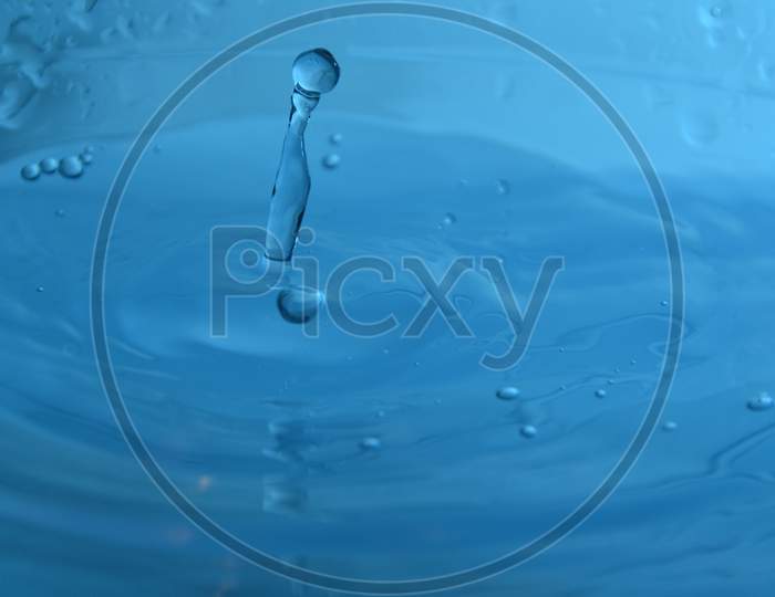 Splash With Drop Of Water With Blue Background