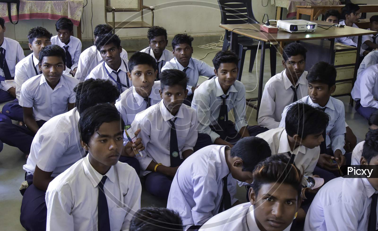 Group of Indian Government school boys students in uniform looking towards blackboard in the classroom of their school. Indian School Students
