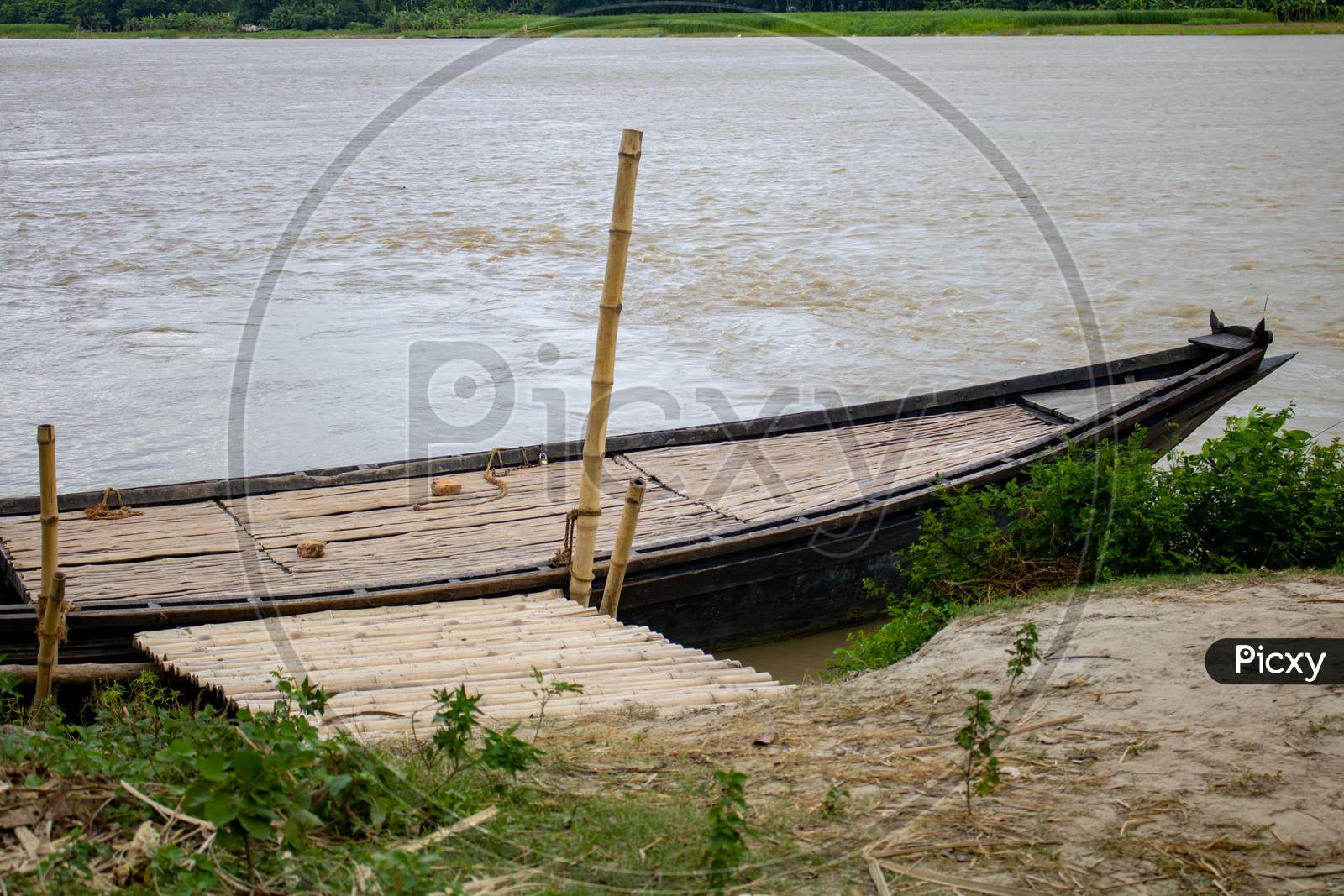 A Large Wooden Boat Tied To The River Bank. This Is A Big River Crossing Boat. A Beautiful River Of Bangladesh.