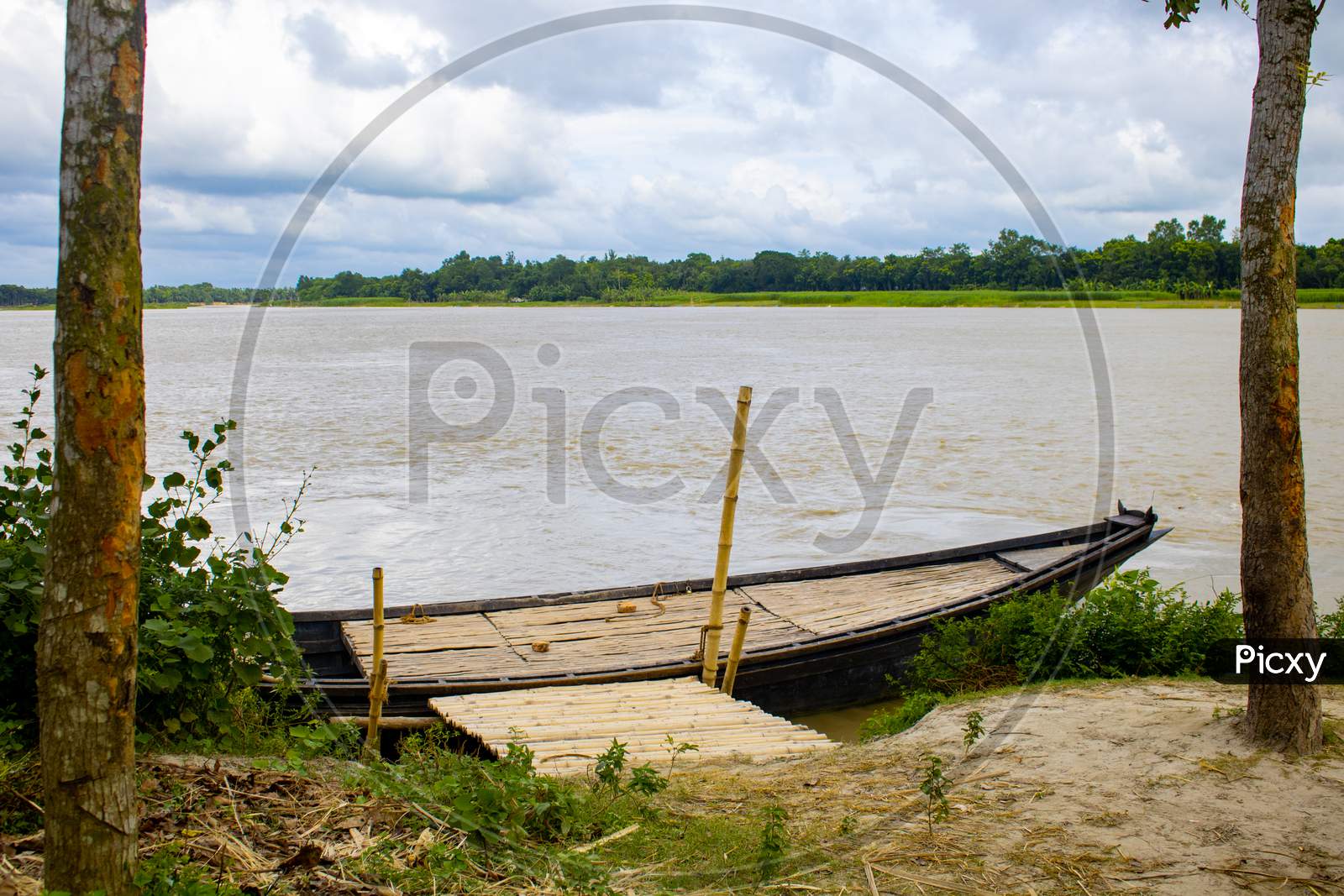 A Large Wooden Boat Tied To The River Bank. This Is A Big River Crossing Boat. A Beautiful River Of Bangladesh.