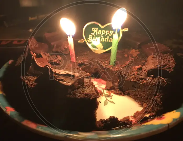 Homemade Happy Birthday cake with candy and flaming candles Stock Photo -  Alamy