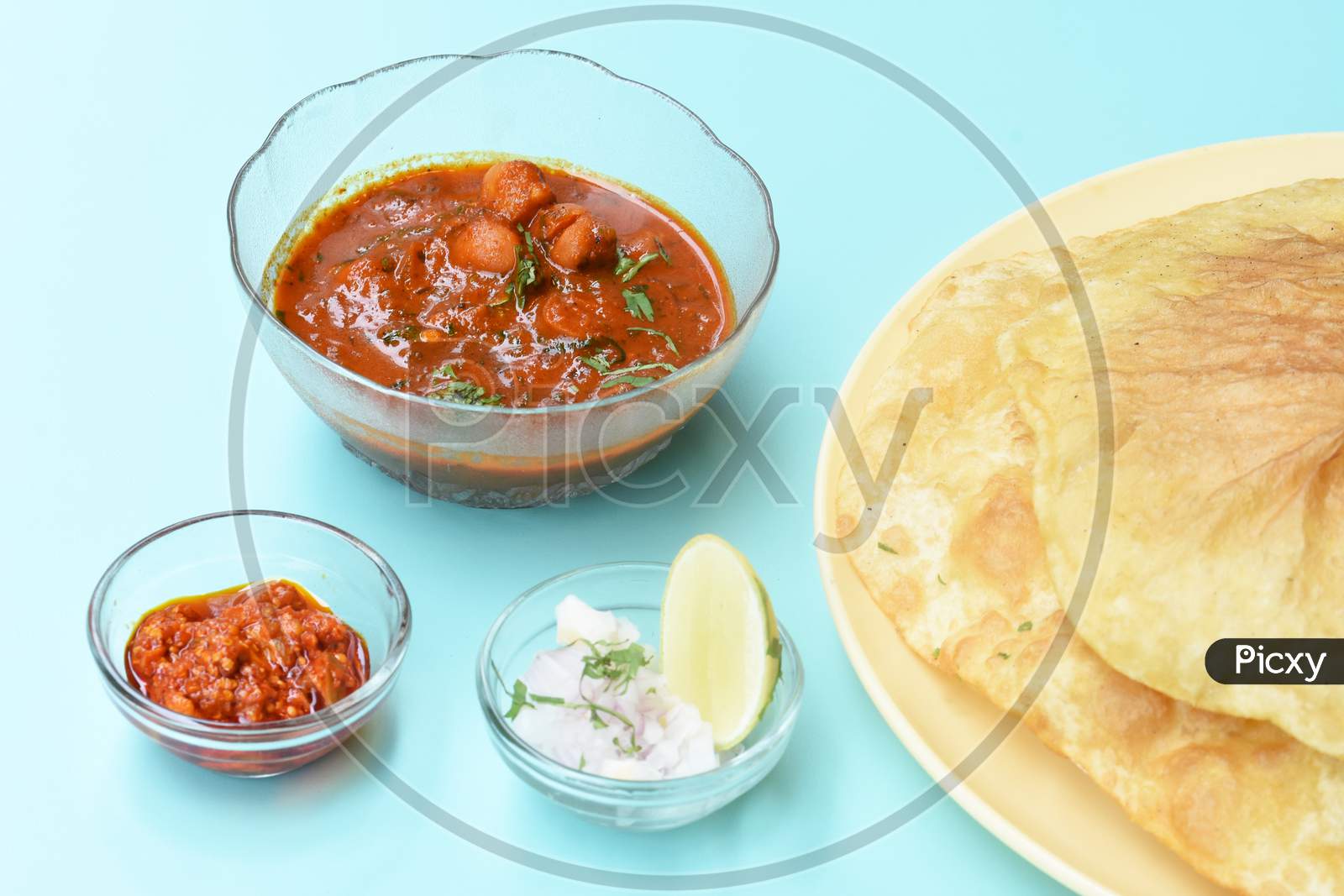 Indian Dish Spicy Chick Peas Curry Also Known As Chole Bhatura And Chana Masala Or Chole Or Chickpeas Masala Curry,Traditional North Indian Lunch Served With Fried Puri Or Flatbreads,Selective Focus