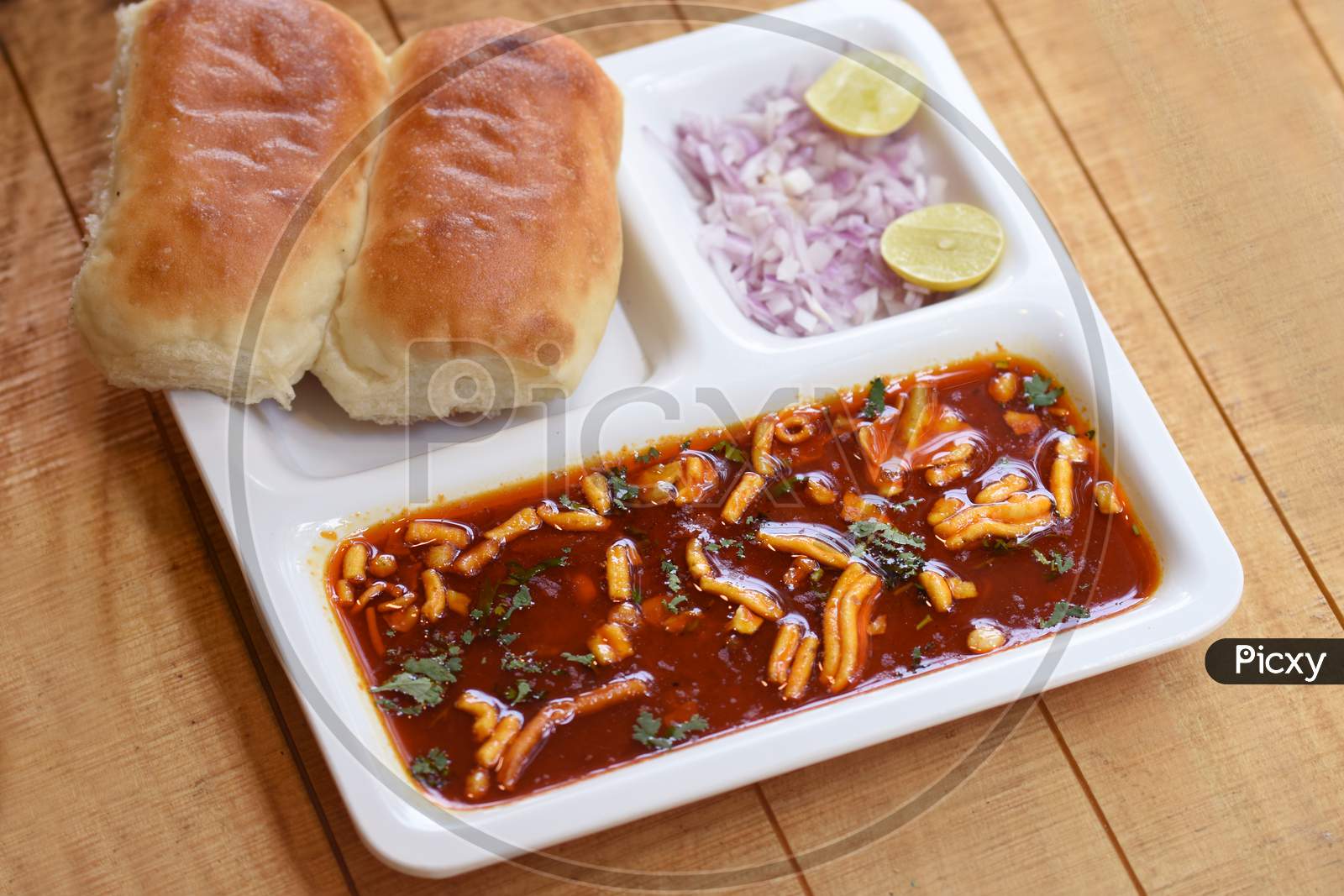 Indian Delicious "Misal Pav" With Onion And Coriander Spread On Top Of Curry Wheat Bread