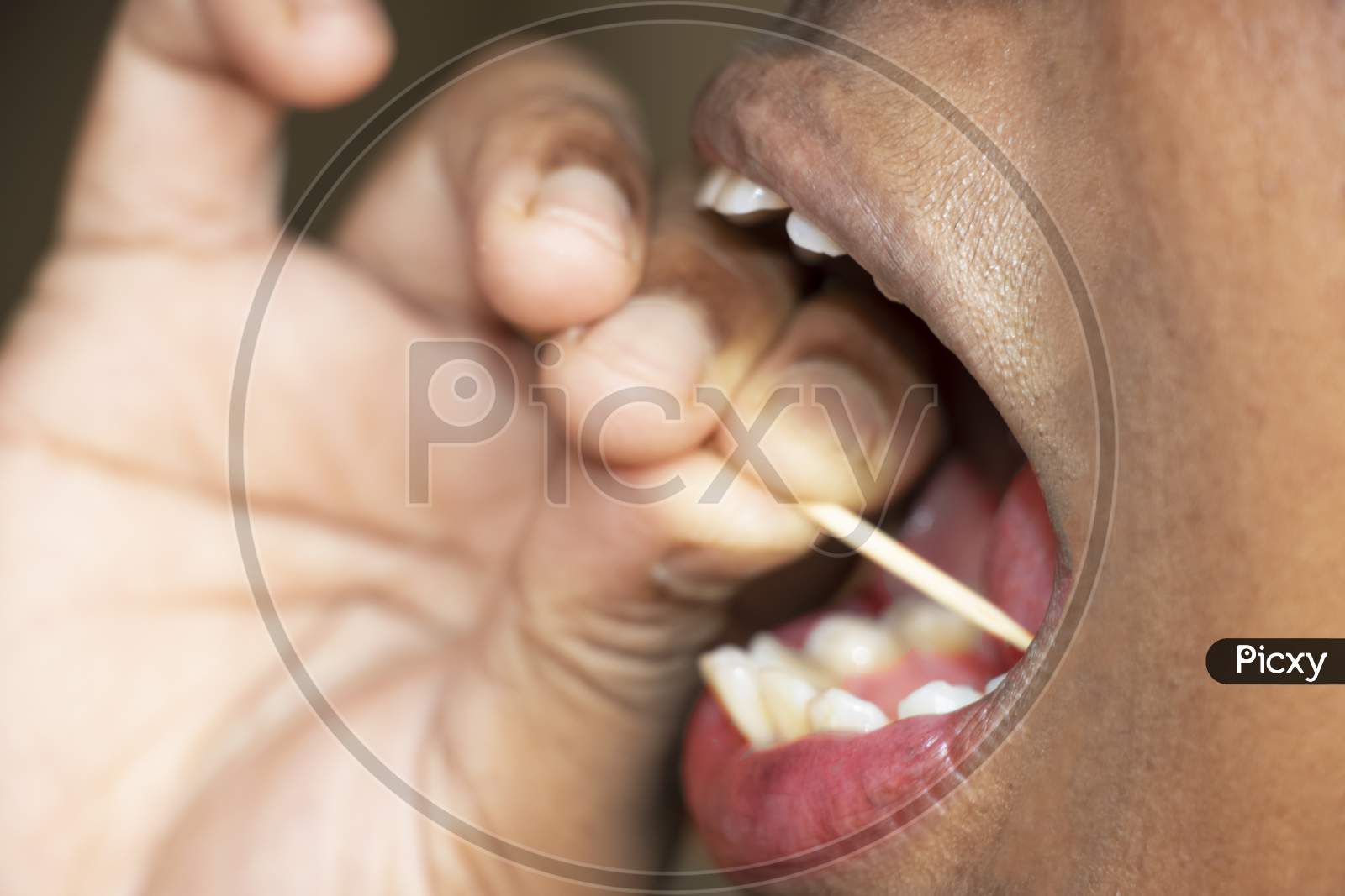 Lady Removing Leftover Food From Teeth With Tooth Pick