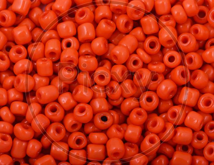 Red Beads On The White Background. Background Or Texture Of Beads. Close Up, Macro,It Is Used In Finishing Fashion Clothes. Make Bead Necklace Or String Of Beads For Woman Of Fashion.